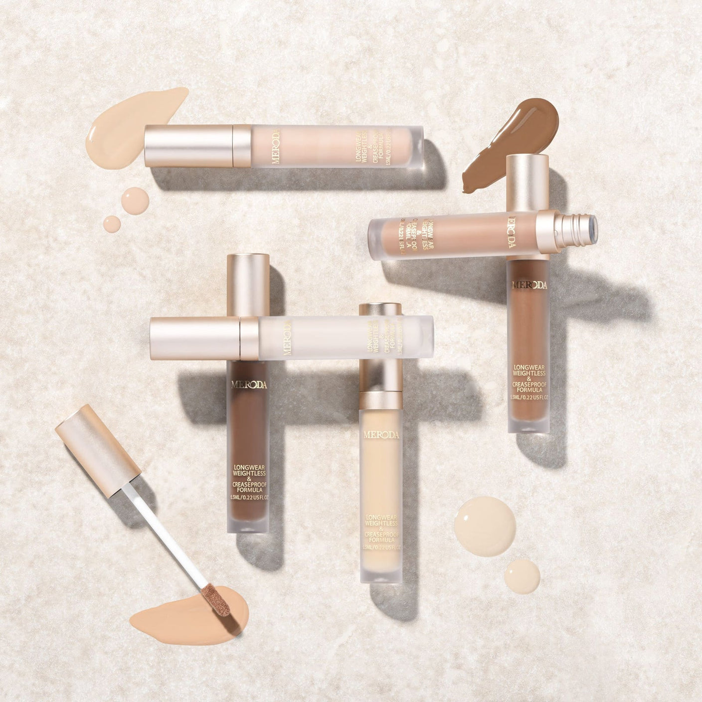 Universal Concealer tubes in various shades with liquid swatches and an applicator wand on a light stone background.
