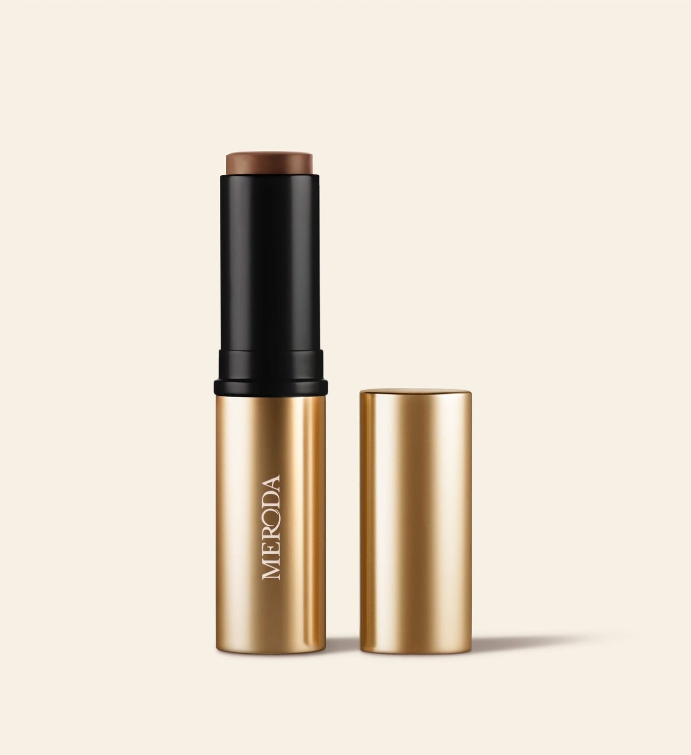 Soft Tan Bronzer in Deep showing the creamy stick formula and sleek gold packaging with the matching cap beside it.