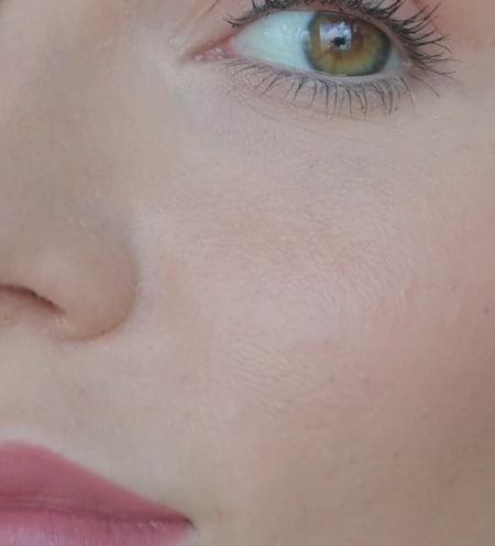 Final Touch Setting Spray bottle held up by a model with radiant skin and pink matte lips.